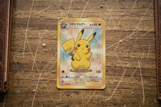 Carte Pokémon Pikachu rare vintage posée sur un bureau en bois usé, vue de dessus en flat lay