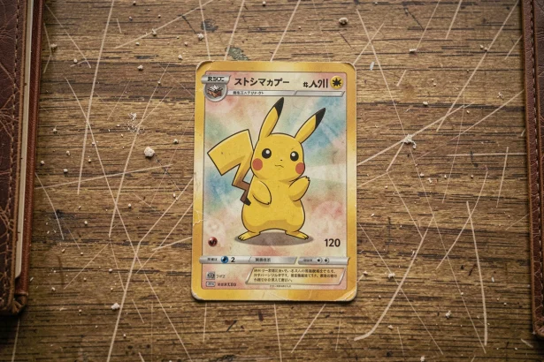 Carte Pokémon Pikachu rare vintage posée sur un bureau en bois usé, vue de dessus en flat lay